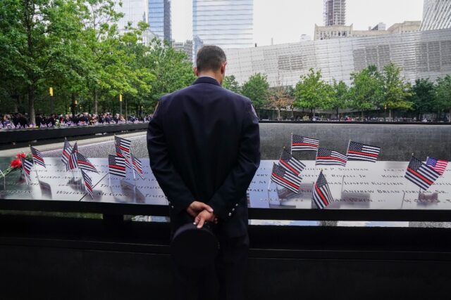 A New York firefighter looks at September 11 victims' names inscribed at the New York memo