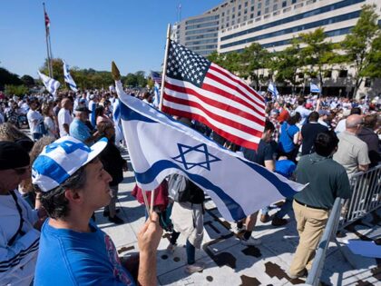 Darren Margolis, of Maryland, waves American and Israeli flags during a rally supporting I