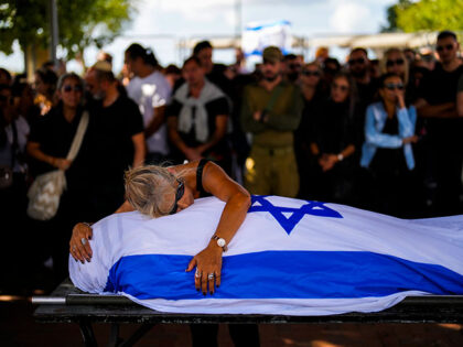 Antonio Macías' mother cries over her son's body, covered with the Israeli flag