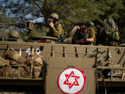 Israeli soldiers drive an armoured personnel carrier (APC) near the border with the Gaza S