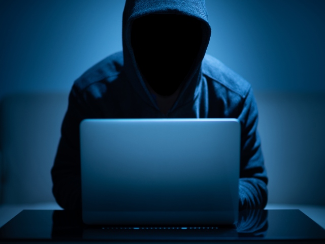 Anonymous hacker at laptop
