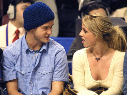 PHILADELPHIA, PA - FEBRUARY 10: Pop superstars Britney Spears (R) and boyfriend Justin Timberlake (L) talk as they sit courtside at the NBA All-Star Game 10 February 2002 in Philadelphia. (Photo credit should read TOM MIHALEK/AFP via Getty Images)
