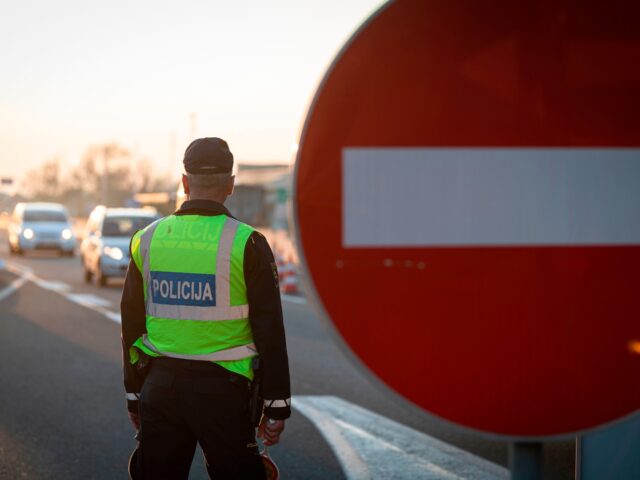 A Slovenian police officer controls traffic at the Slovenian-Italian border crossing near