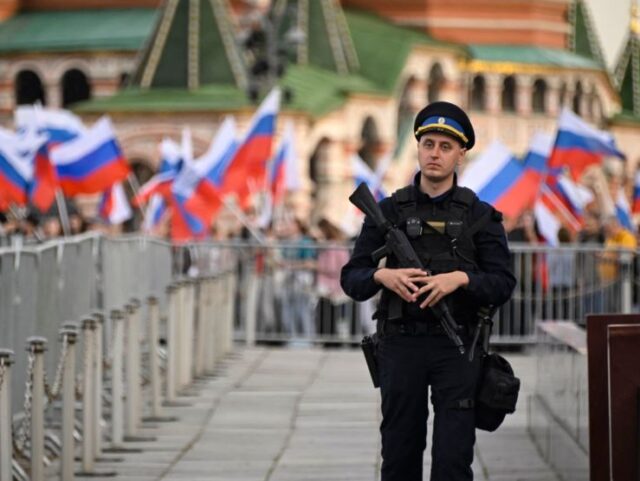 A law enforcement officer stands guard as people gather for a concert dedicated to the first anniversary of the annexation of four regions of Ukraine Russian troops control - Lugansk, Donetsk, Kherson and Zaporizhzhia, at Red Square in central Moscow on September 29, 2023. (Photo by Alexander NEMENOV / AFP) …