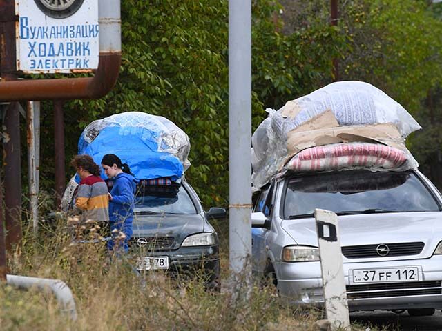 Ethnic Armenian refugees from Nagorno-Karabakh wait on the side of the road in the town of