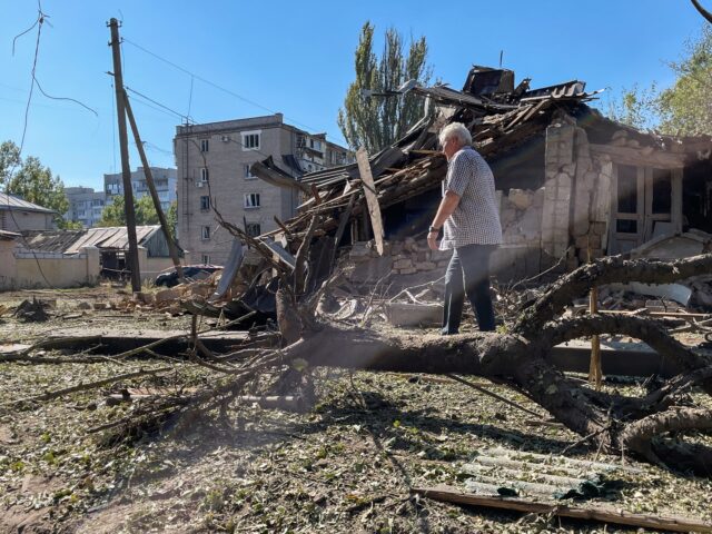 KHERSON, UKRAINE - SEPTEMBER 26: A person walks amid debris past a residential house destr