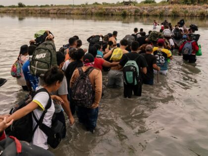 Migrants cross the Rio Grande at the US-Mexico border in Piedras Negras, Coahuila state, Mexico, on Friday, Oct. 6, 2023. Mexico, along with President Joe Biden's administration and the United Nations, is considering setting up a temporary program to help pre-screen tens of thousands of migrants for US entry eligibility as border …