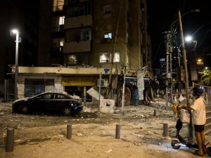 TEL AVIV, ISRAEL - OCTOBER 07: A man passes the scene where a rocket fired from Gaza strip