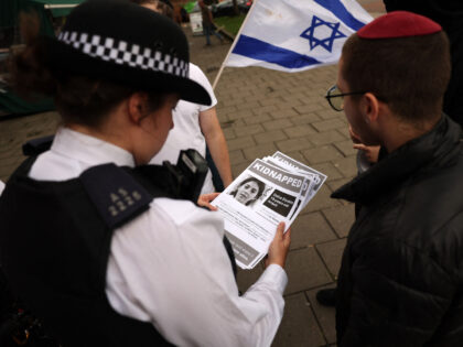 A group of young Jewish men speak with police officers as they put up posters showing rece