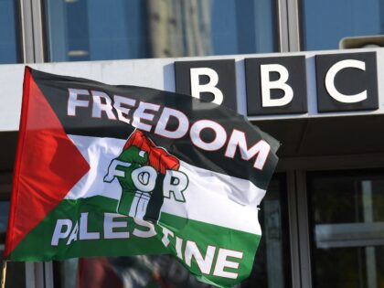 A Palestinian flag is waved outside the BBC Scotland building as people take part in a dem