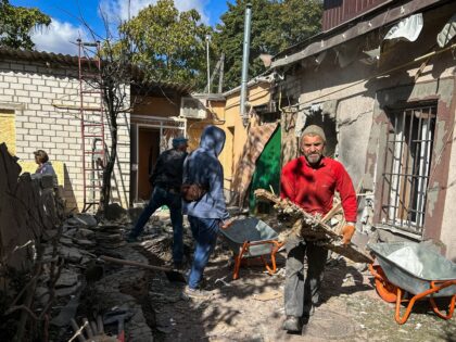 KHERSON, UKRAINE - OCTOBER 9: Local residents clean up the rubble in a damaged residential