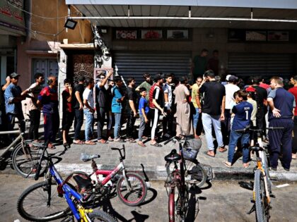 KHAN YUNIS, GAZA - OCTOBER 15: Palestinians line up in front of a bakery to buy bread afte