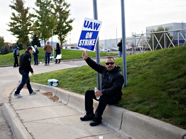 A "UAW On Strike" sign held on a picket line outside the Stellantis Sterling Hei