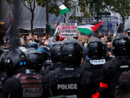 TOPSHOT - A protester holds a placard reading "Support Palestinian Unions Stop arming Isra