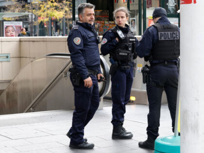 French police officers stand at the entrance of a metro station after a woman making threa