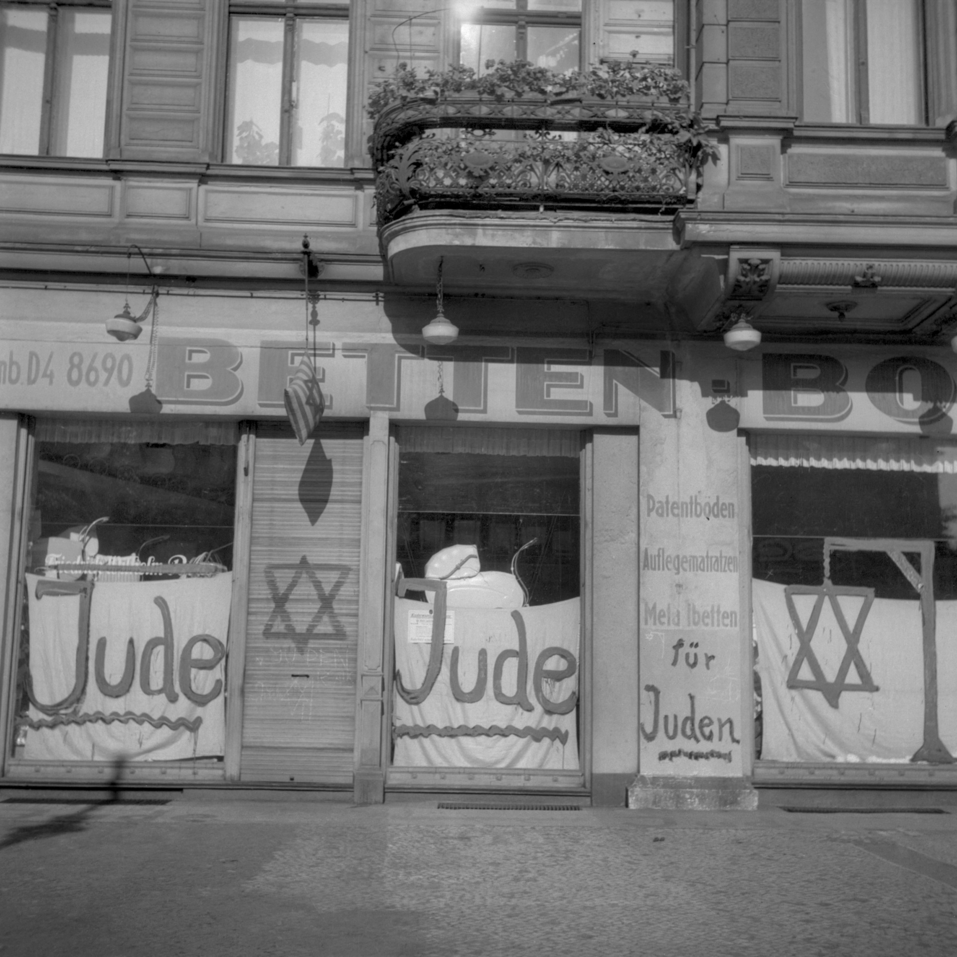 TOPSHOT - A picture taken in Berlin shows a Jewish-run shop inscripted with nazi antisemitic graffitis during the June 1938 antisemitic campaign. Ordered by the Nazi party NSDAP in November 1938, rioters burnt down 267 synagogues, shattered the windows of some 7500 Jewish shops, desecrated Jewish cemeteries and beat people, 09 November 1938. Splintering glass panes and broken glass in the streets gave the pogrom the downplaying name "Reichskristallnacht", or Crystal Night. AFP PHOTO / FRANCE PRESSE VOIR (Photo by PIGISTE / FRANCE PRESSE VOIR / AFP) (Photo by PIGISTE/FRANCE PRESSE VOIR/AFP via Getty Images)