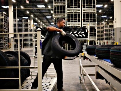A worker loads automotive tires onto a conveyor belt at the Continental Tire Sumter plant