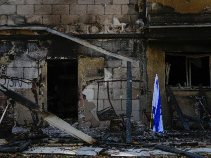 An Israeli flag is placed next to a house destroyed by Hamas militants in Kibbutz Be'