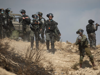 Israeli border policemen fires tear gas at Palestinian protesters during clashes as they p