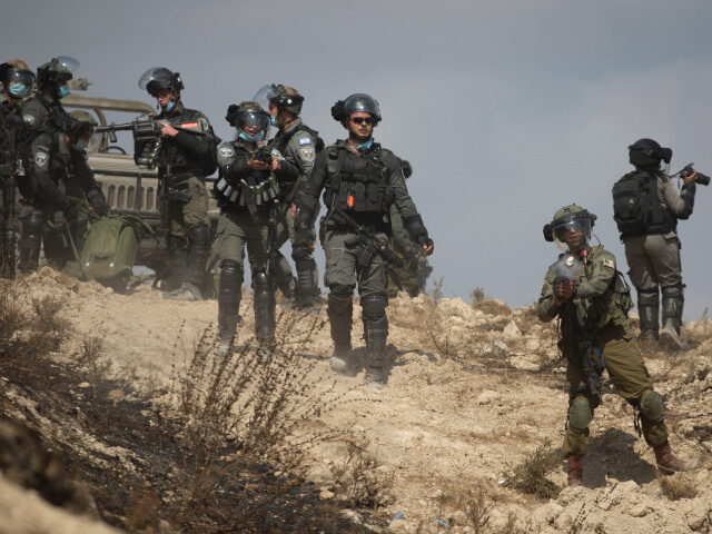 Israeli border policemen fires tear gas at Palestinian protesters during clashes as they p