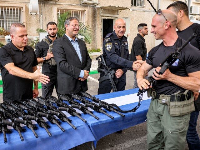 Israel's National Security Minister Itamar Ben-Gvir (C) looks on as volunteers of the