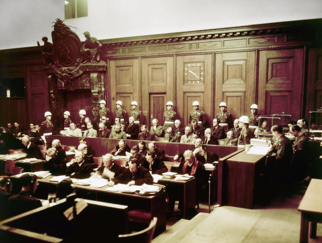 War crimes trial in progress in Nuremberg, Germany sometime in 1946. German prisoners are seated in front of long line of helmeted U.S. Military Police. (AP Photo)