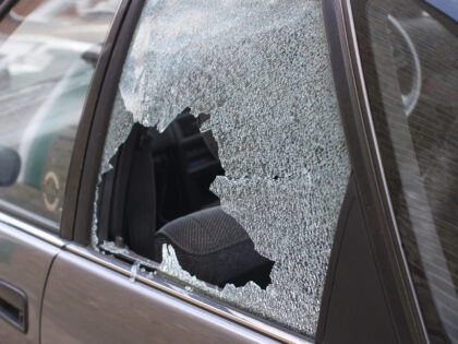 Thief broken glass in car window - stock photo