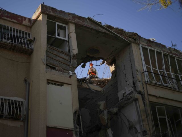 A Israeli soldier inspects a damaged residential building, a day after it was hit by a roc