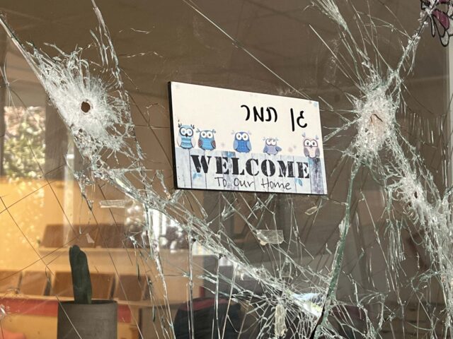 A kindergarten door is shattered with bullet holes at Kibbutz Be'eri in the aftermath