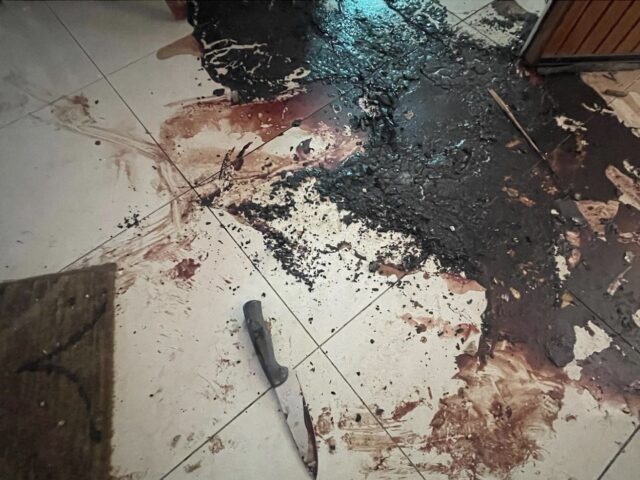 A knife is seen on the floor amid the congealed blood of the victims in one of the homes w
