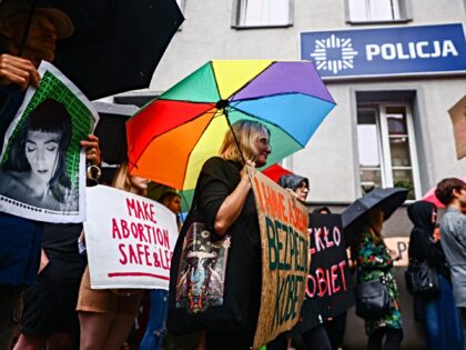 People hold banners while demonstrating outside a police station during 'Solidarity w