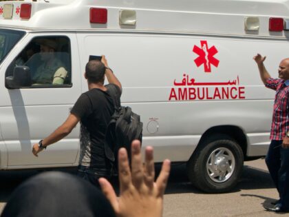 An Egyptian mourner waves to an ambulance carrying the coffin of Egyptian-American Nobel c