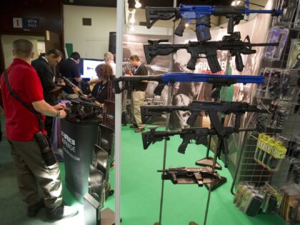 A man stops at a booth displaying guns and rifles on June 30, 2010, at a security trade ex