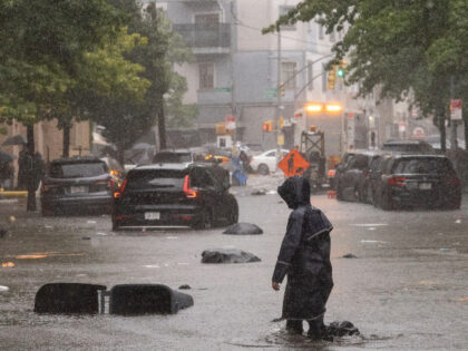 New York, NY - September 29: A person walks on a flooded str