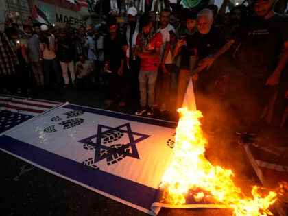 Supporters of the religious party Majlis Wahdat-e-Muslimeen Pakistan burn representations of Israeli and US flags during a protest against Israeli airstrikes on Gaza, to show solidarity with the Palestinian people, in Karachi, Pakistan, Sunday, Oct. 22, 2023. (AP Photo/Fareed Khan)