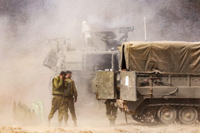 An Israeli army self-propelled howitzer fires rounds near the border with Gaza in southern