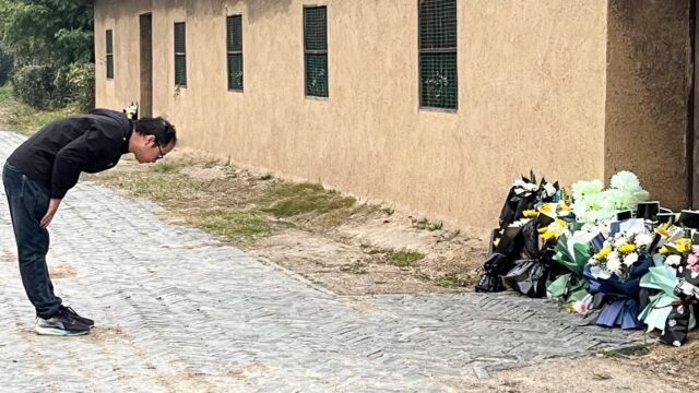 A man bows in front of the former house of China's ex-premier Li Keqiang, who died Friday