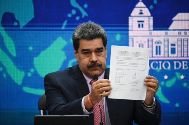 El presidente Nicolás Maduro muestra el acuerdo firmado entre su delegación y la oposici