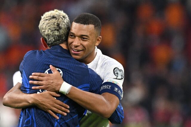 France forwards Antoine Griezmann and Kylian Mbappe em,brace after securing Euro 2024 qual