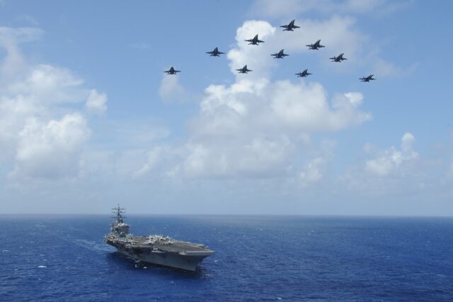 In this image released by the US Department of Defense, F/A-18C Hornets fly over the USS D