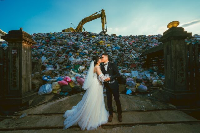 Iris Hsueh (L) and her fiance Ian Ciou take a wedding photo in front of a huge mound of ga