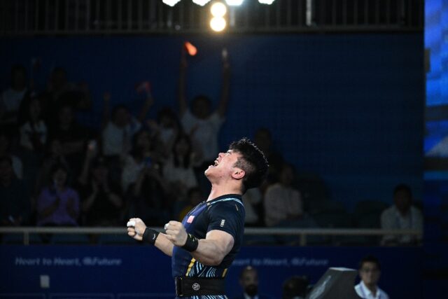 Liu Huanhua celebrates after snatching gold in the men's 109kg weightlifting