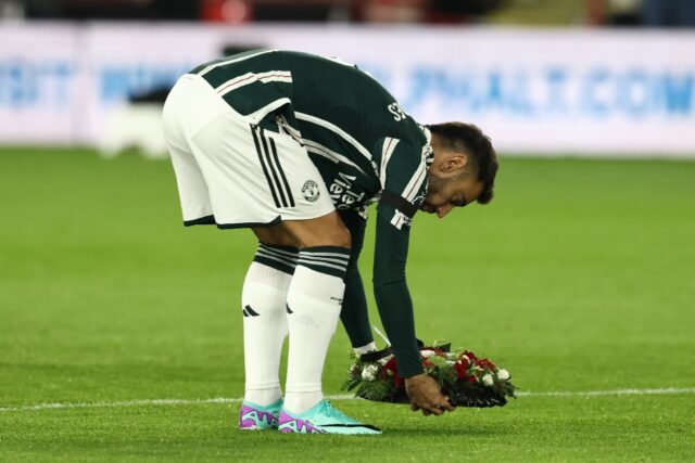 Manchester United captain Bruno Fernandes lays a floral wreath in tribute to the late Bobb