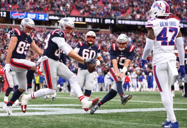 Mike Gesicki celebrates with New England quarterback Mac Jones after scoring the winning t