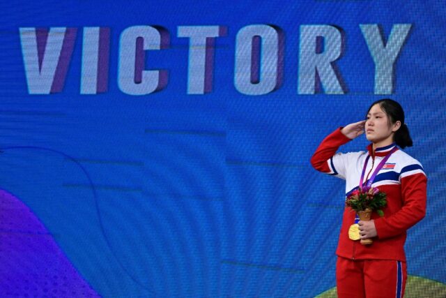 North Korea's Kim Il Gyong salutes with her gold medal during the medal ceremony for the w