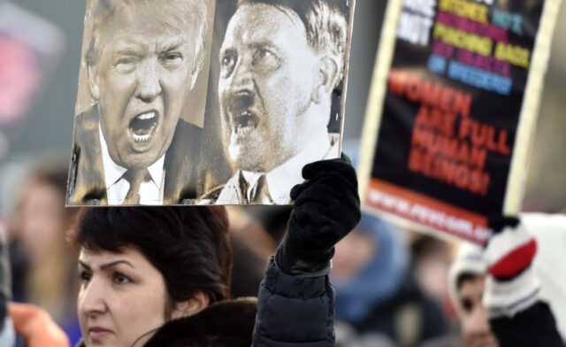 A participant of a Women's March in Helsinki holds up a poster depicting US President Dona