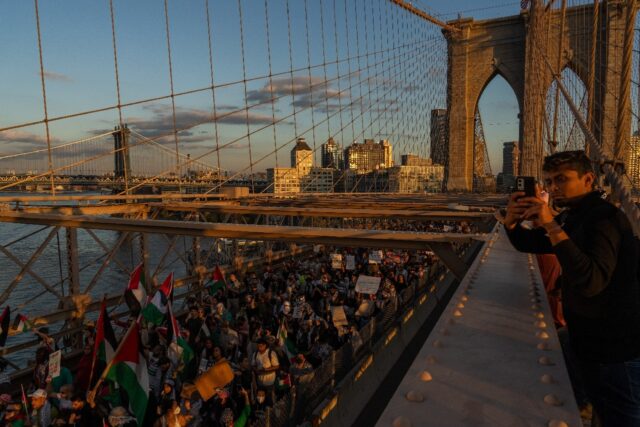 People cross the Brooklyn Bridge as they take part in a protest in support of the Palestin