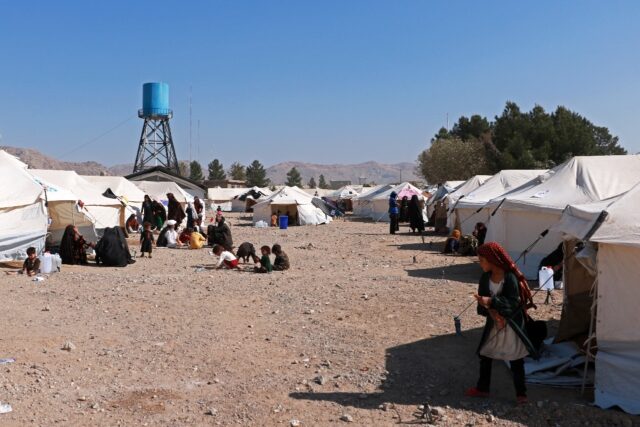 People sit outside tents set up near Herat city after a series of quakes and aftershocks h