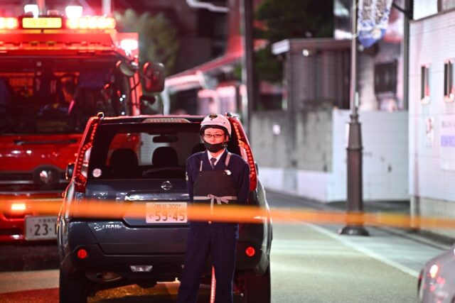Police officers guard the area around a post office where a suspected gunman has taken an