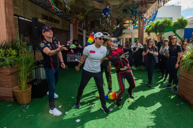 Red Bull's drivers Max Verstappen (left) and Sergio Perez (centre) throw candy to fans i